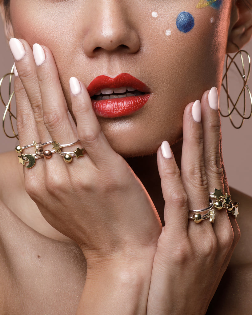 Model is wearing Stackable Sterling Silver ring with Brass Star, Planet and Moon